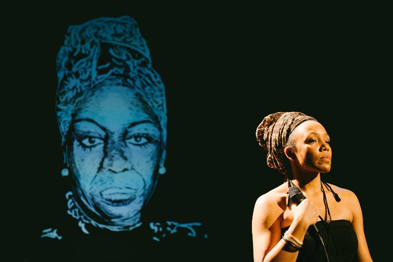 Nina Simone steht auf der Bühne mit Mikrofon